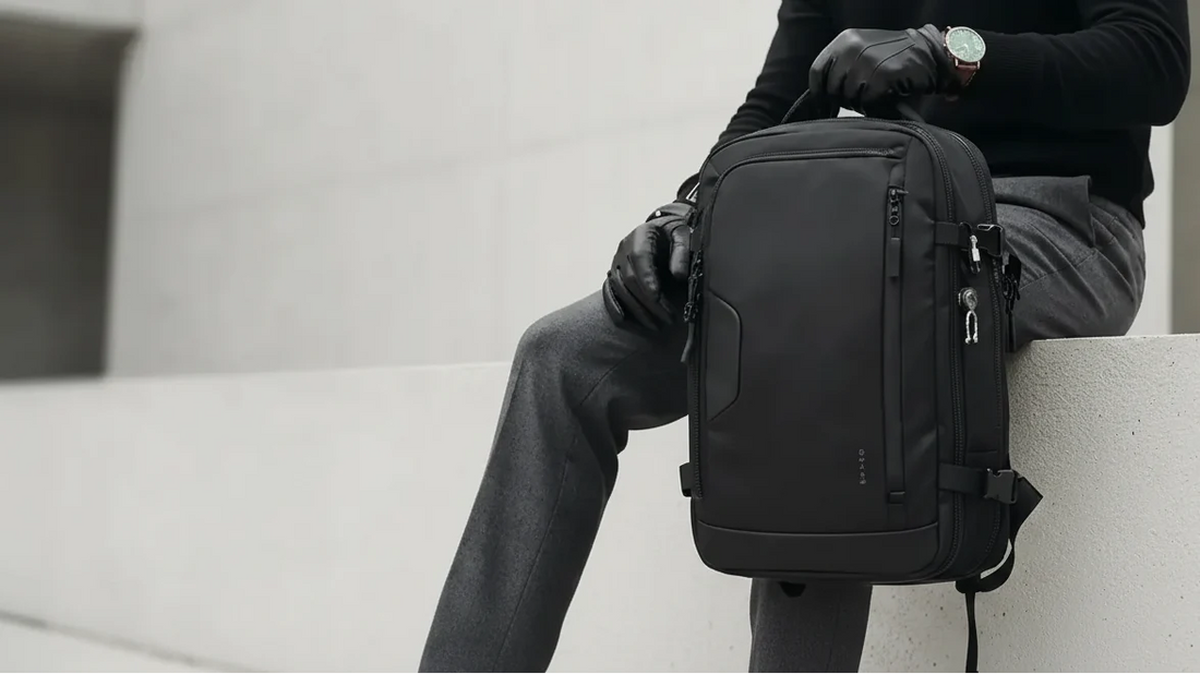 Homme portant un sac à dos noir en bandoulière, sac à dos cabine Bange